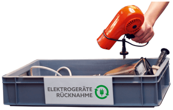Person legt Föhn in Box mit anderen Elektroaltgeräten.