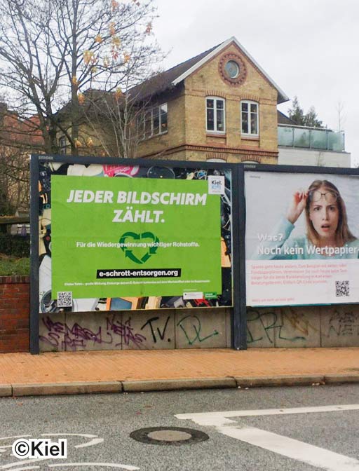 Ein Aktionsplakat mit der Überschrift "Jeder Bildschirm zählt" an eine Parkplatz.